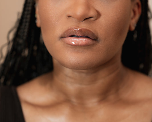 Close-up of a woman's neck and shoulders with a neutral background