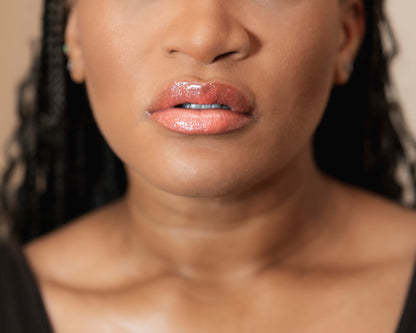Close-up of a woman's face with a focus on her lips wearing pink lipstick.