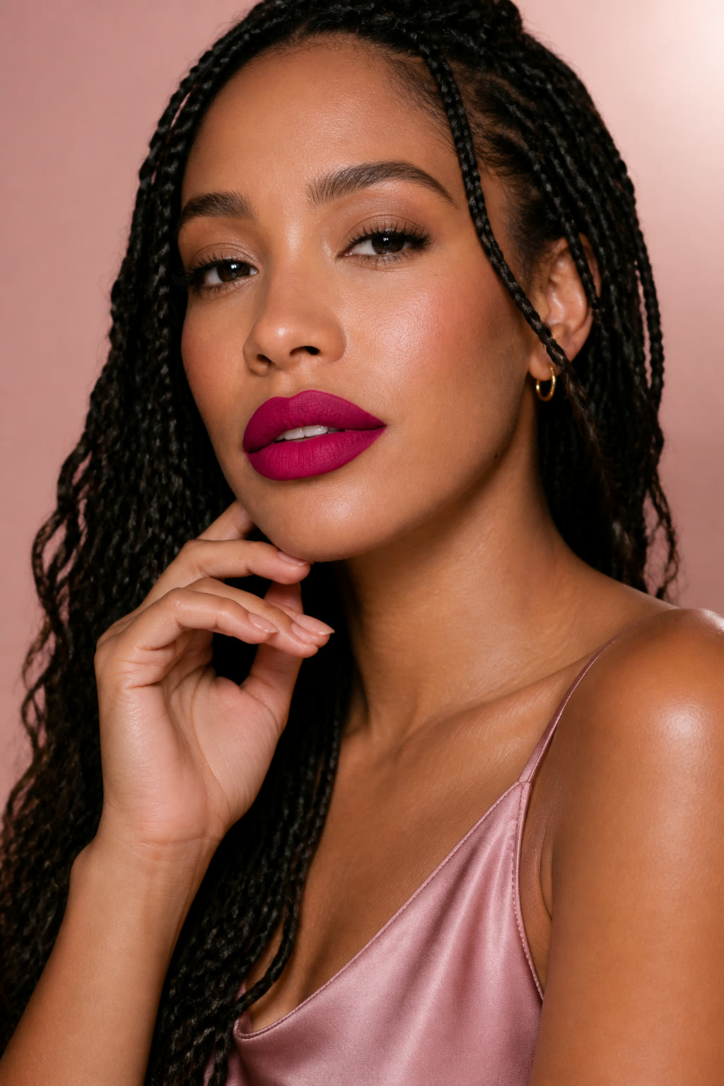 Woman with long braids wearing a rich berry statement lip